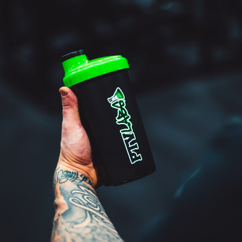 Shaker kädessä – musta treenijuomapullo vihreällä kannella kuntosalikäyttöön