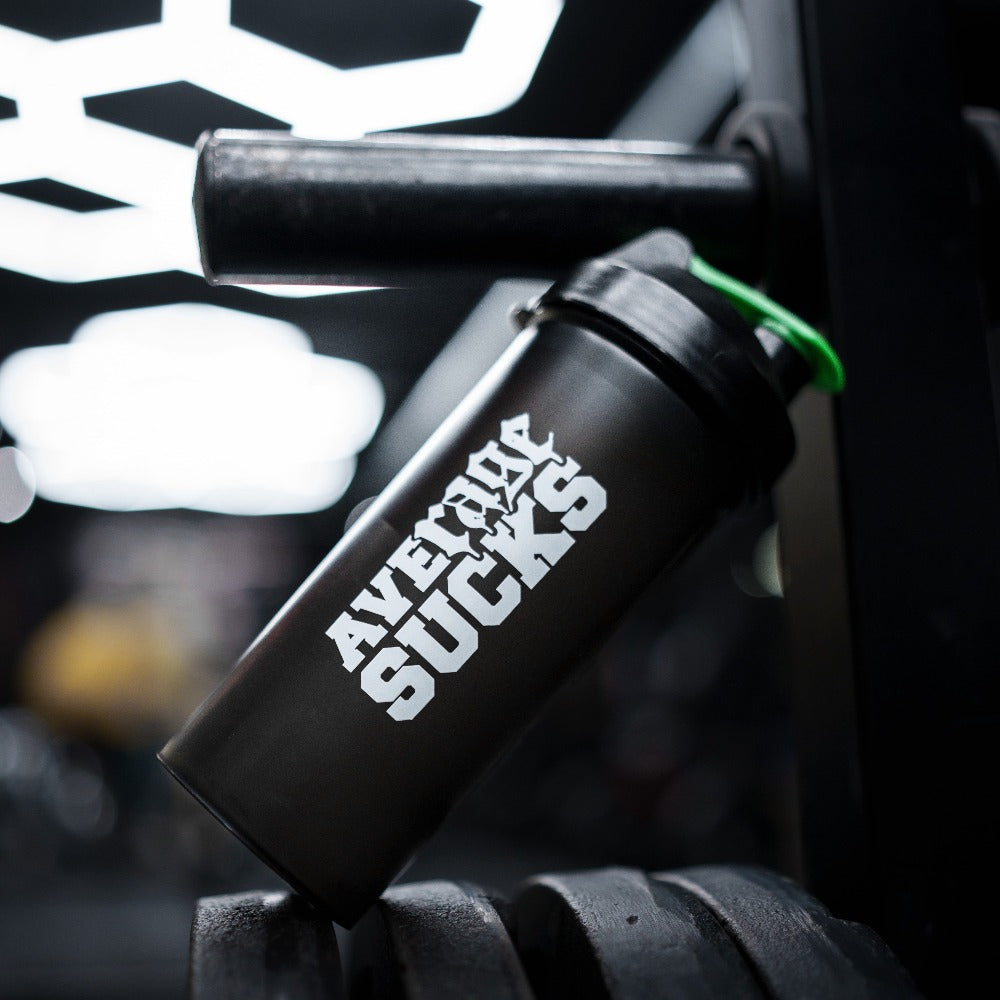 Smartshake-shaker salilla – musta Average Sucks -shaker vihreällä kannella levytankotelineessä